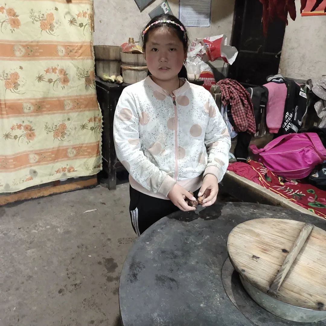 佳媛一边烧水，一边给弟弟妹妹剥栗子.jpg