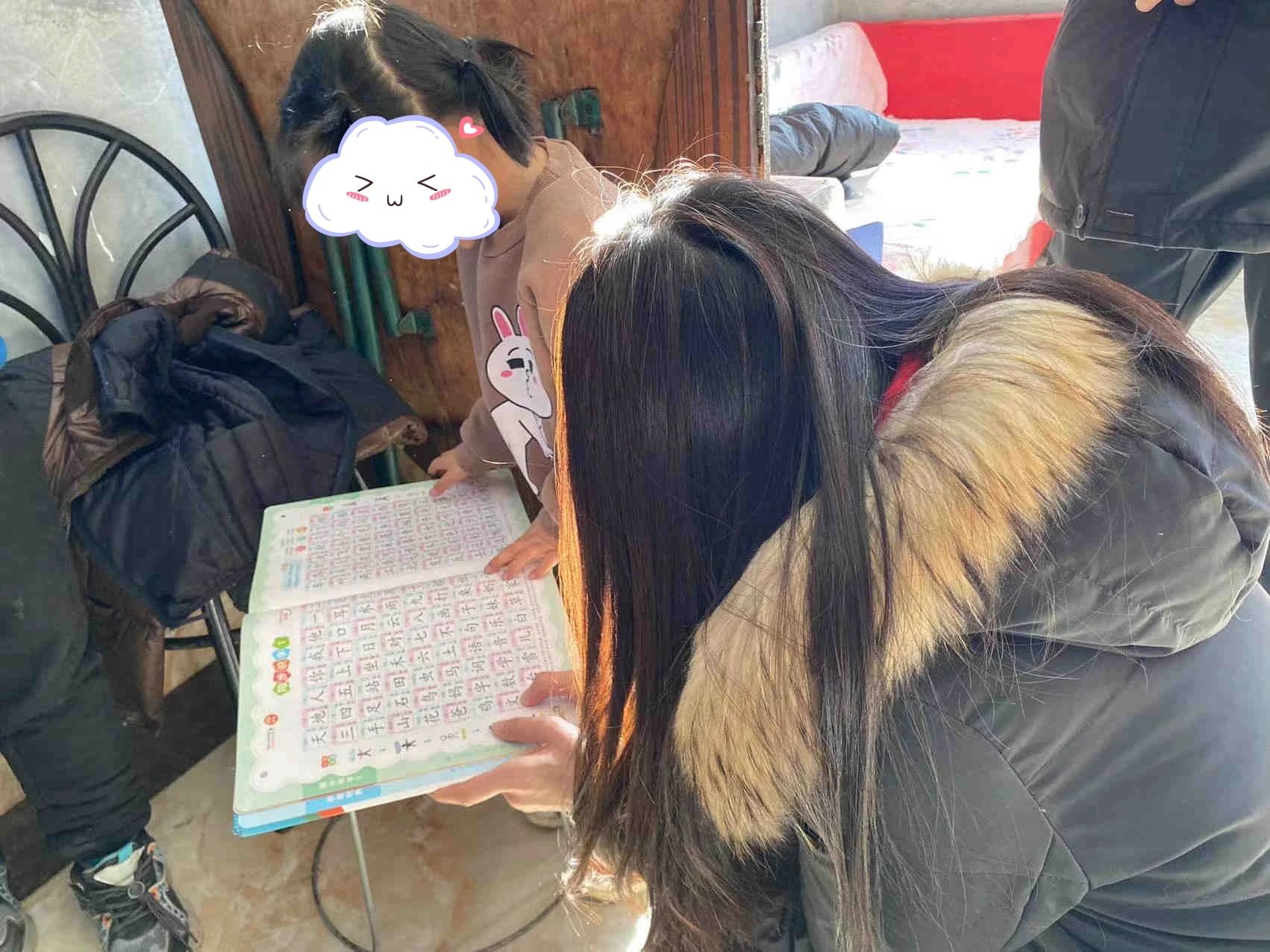 小男孩的妹妹正在学习拼音，志愿者陪她一起朗读练习.jpg